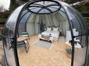 a bedroom in a dome tent with a bed at Entre Ciel et Rivière in Bouillon