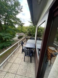 a patio with a table and chairs on a balcony at Au Bout du Monde - Dinant in Waulsort