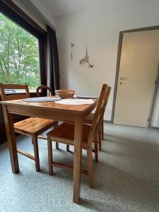 a wooden dining room table with chairs and a window at Au Bout du Monde - Dinant in Waulsort +1 photo