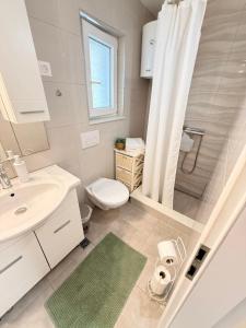 a bathroom with a toilet and a sink and a shower at Apartments Garmaz in Podgora +84 photos