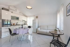 a kitchen and living room with a table and chairs at Apartments Sonja in Pučišća