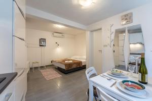 a room with a bed and a table with a dining room at Apartments Sonja in Pučišća
