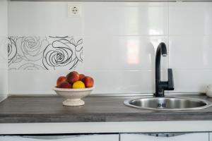 a bowl of fruit on a counter next to a sink at Apartments Sonja in Pučišća +62 photos