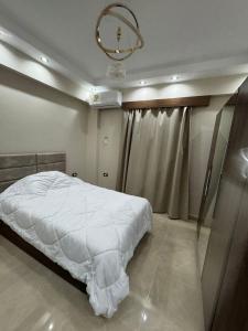 a bedroom with a white bed and a chandelier at Sharm Glow Villa in Sharm El Sheikh