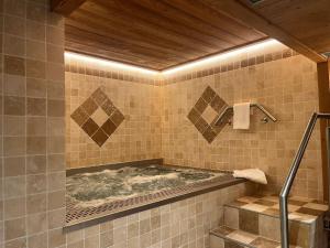 a bathroom with a hot tub in at Logis La Croix-Saint-Maurice in Le Grand-Bornand +44 photos