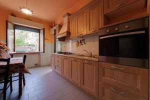a kitchen with wooden cabinets and a large microwave at Appartamento Pomonte la Posta - Goelba in Pomonte