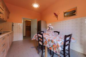 a kitchen with a table with chairs and a refrigerator at Appartamento Pomonte la Posta - Goelba in Pomonte
