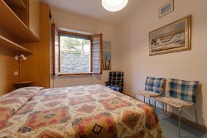 a bedroom with a bed and two chairs at Appartamento Pomonte la Posta - Goelba in Pomonte