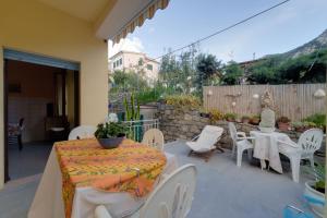 a patio with a table and chairs and a fence at Appartamento Pomonte la Posta - Goelba in Pomonte
