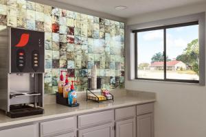 a tile wall in a kitchen with a window at Home Inn & Suites in Orlando