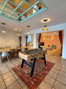 a living room with a foosball table on a rug at Matsya Hostel in Anglet