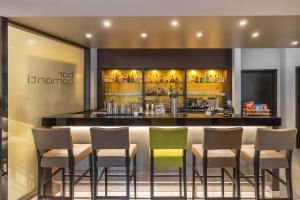 a bar in a hotel with chairs and a counter at hotel bomonti Nürnberg West in Oberasbach
