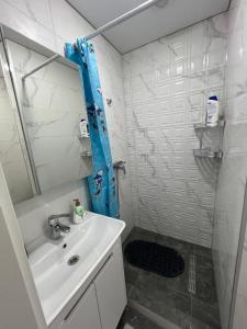 a white bathroom with a sink and a shower at Apartaments Briceni city in Briceni