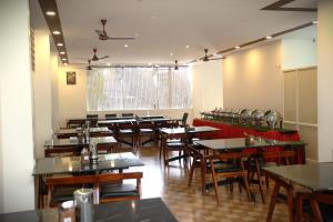 a dining room filled with tables and chairs at Delano Residency in Kaliyal