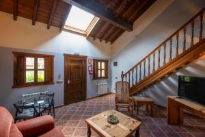 a living room with a staircase and a table at Hotel La Lluriga in La Galguera