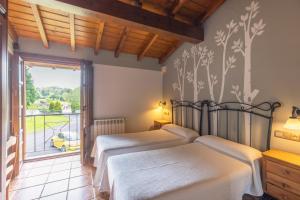 a bedroom with two beds and a large window at Hotel La Lluriga in La Galguera +45 photos
