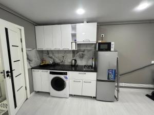 a kitchen with white cabinets and a washer at Apartaments Briceni city in Briceni