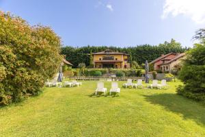a group of chairs sitting in the grass in front of a house at Hotel La Lluriga in La Galguera