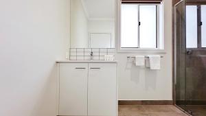 a white bathroom with a sink and a shower at Westbrook 3B3B Home by GoodLive in Truganina +28 photos