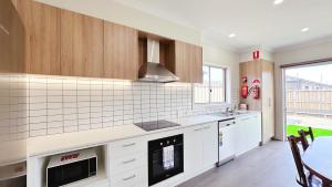 a kitchen with white cabinets and a stove top oven at Westbrook 3B3B Home by GoodLive in Truganina