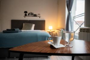 a room with a bed and a table with a glass at MiniCity Inn in Belgrade