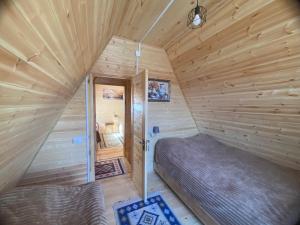 a small room with a bed in a log cabin at Guesthouse Venera in Mestia