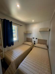 two beds in a small room with a window at Camping Village Butterfly in Peschiera del Garda +92 photos