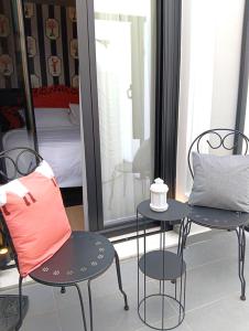 a room with two chairs and a table and a bed at Lord Byron Luxury Suites in Missolonghi