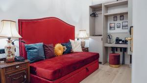 a red couch with pillows on it in a room at Lord Byron Luxury Suites in Missolonghi +50 photos