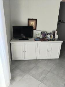 a white cabinet with a television on top of it at la casa di Shanti in Avigliana