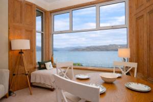 a dining room with a table and a large window at Kames View Apartment in Tighnabruaich