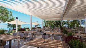 a restaurant with tables and chairs under a white canopy at Easyatent Mobile home Zelena Laguna in Poreč