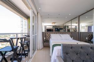 a bedroom with a bed and a table and chairs at The Expression Building - Setor Bueno - THP in Goiânia