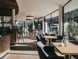 a restaurant with tables and chairs and windows at VAYA Zell am See in Zell am See