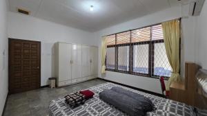 a bedroom with a large bed and a large window at Rumah Mewah Johar in Pontianak
