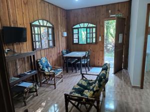a living room with a table and chairs at Brisa da Mata Ecolodges in Morretes