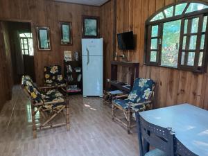 a living room with chairs and a refrigerator at Brisa da Mata Ecolodges in Morretes