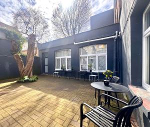 a patio with a table and chairs and a tree at Сarnot Apartments ZOO Area in Antwerp