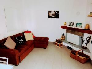 a living room with a red couch and a fireplace at da Roy in Scansano