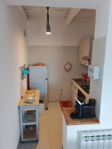 a small kitchen with a refrigerator and a table at da Roy in Scansano