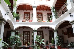a courtyard of a building with tables and potted plants at Hotel Casa de la Tía Tere in Oaxaca City