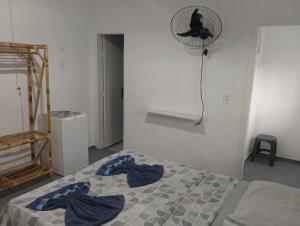a bedroom with a bed with blue sheets and a fan at Residencial Portuguesa in Natal