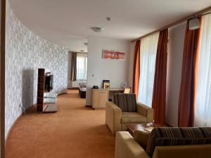 a living room with a couch and a tv at Hotel Legend in Dunajská Streda