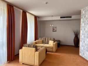 a living room with two chairs and a couch at Hotel Legend in Dunajská Streda