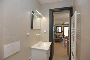 a white bathroom with a sink and a mirror at VF34 Patio House in Ermoupoli +39 photos