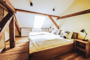 a bedroom with a large bed in a room with wooden floors at Residence Legio XIII Gemina in Ptuj