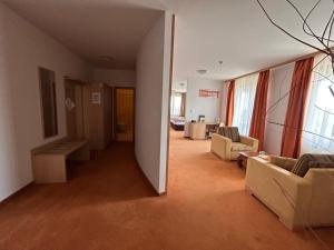 a living room with two couches and a table in a room at Hotel Legend in Dunajská Streda
