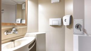 a white bathroom with a sink and a mirror at Premiere Classe Limoges Nord in Limoges +29 photos