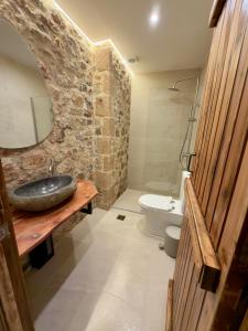 a bathroom with a sink and a toilet and a mirror at Eleon apartments in Kalamata +8 photos