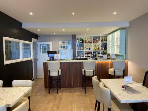 a restaurant with a bar with white chairs and tables at OPUL EXPRESS - Inglewood in Douglas